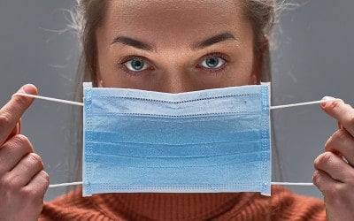 Gezonde vrouw met behulp van medisch beschermend masker voor bescherming van de gezondheid